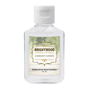 clear hand sanitizer bottle with white cap and an imprint saying brightwood community garden