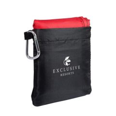 red picnic blanket with a black pouch attached to a silver carabiner and an imprint on the front of the pouch saying exclusive resorts