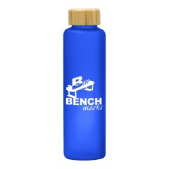 blue glass bottle with a bamboo lid and an imprint saying Benchmarks