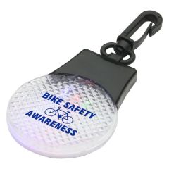 clear circle safety light with a black carabiner and an imprint saying Bike Safety Awareness