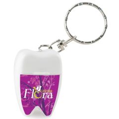 a white tooth-shaped floss keychain with an imprint saying Flora Center
